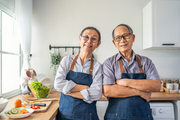 Portrait of senior elderly couple wear apron smiling, look at camera. 