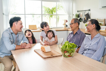 Asian big happy family have lunch on eating table together in house
