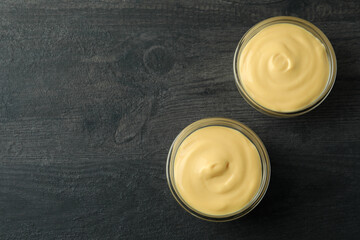 Bowls with cheese sauce on dark background