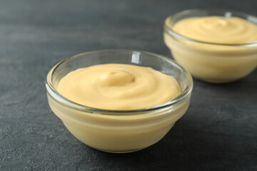 Bowls with cheese sauce on dark background