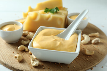 Board with cheese sauce and ingredients, close up