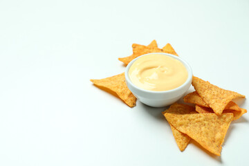 Bowl with cheese sauce and chips on white background