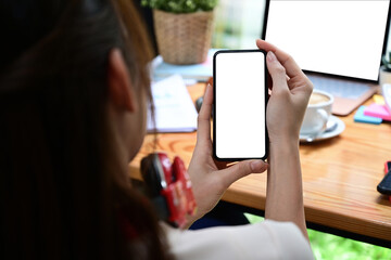 Close up view female using mobile phone at office desk.