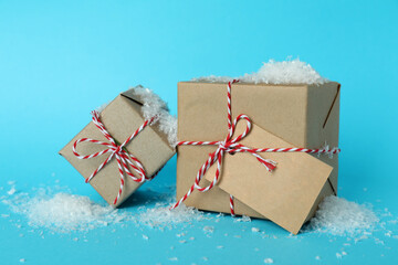 Craft gift boxes and snow on blue background