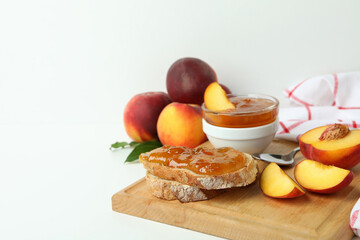 Peach jam, sandwich with peach jam and ingredients on white table