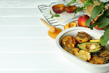Concept of tasty food with grilled peach on white wooden table