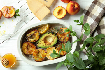 Concept of tasty food with grilled peach on white wooden table