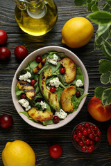 Concept of tasty food with salad with grilled peach on wooden table