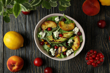 Fototapeta na wymiar Concept of tasty food with salad with grilled peach on wooden table