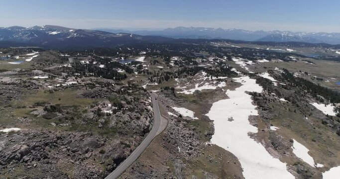 Aerial view of cars on Beartooth Highway  in Wyoming near Yellowstone National Park. Rocks partially cover with snow on the border of Montana and Wyoming