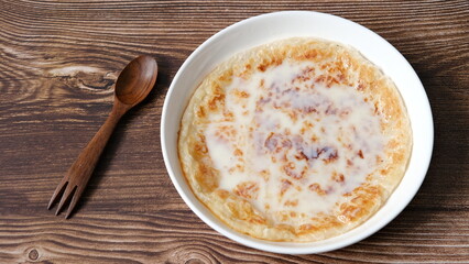 Chapati a thin pancake known as roti topping with sweet condense milk, Indian traditional street food.