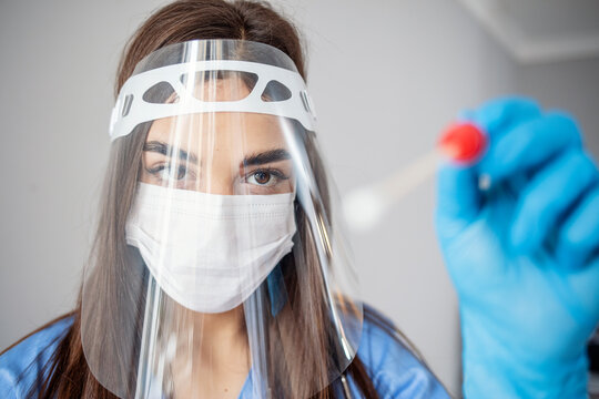 Medical healthcare technologist holding COVID-19 swab collection kit, wearing white PPE protective suit mask gloves, test tube for taking OP NP patient specimen sample,PCR DNA testing protocol process