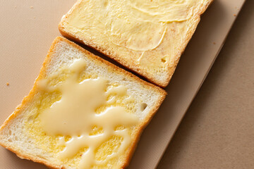 sliced ​​white bread Topped with margarine, sweetened condensed milk on a brown chopping board background.