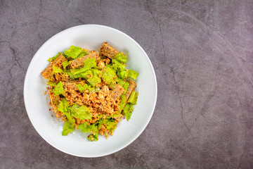 Thai spicy Vietnamese sausage with minced chicken, fish sauce, lime juice, lettuce salad on a white plate.