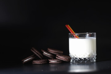 Milk drink in a glass. Farm milk and cookies. Delicious snack with cow's milk and fresh pastries.