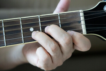 hand holding guitar chord for playing