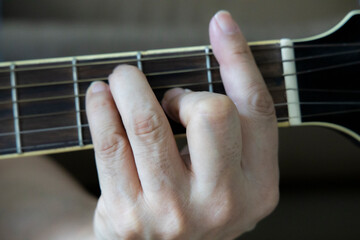 hand holding guitar chord for playing