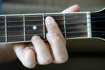 hand holding guitar chord for playing