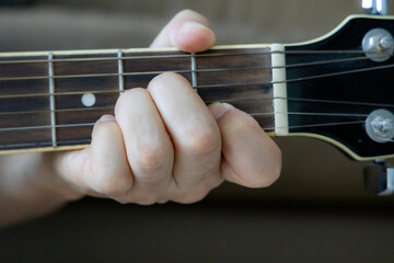 hand holding guitar chord for playing