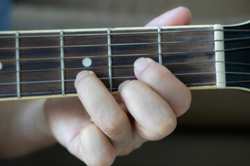 hand holding guitar chord for playing