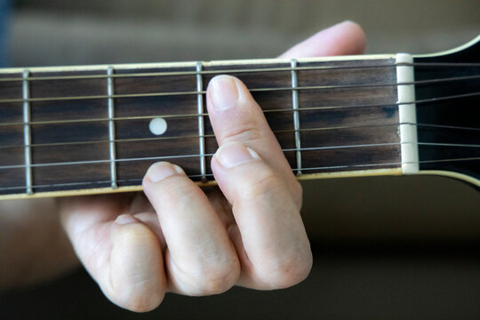 hand holding guitar chord for playing