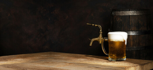 Beer barrel with beer glasses on a wooden table. Dark amber background.