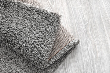 Grey carpet on wooden floor, closeup