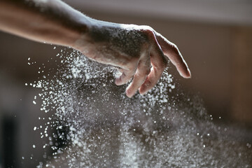Flour wakes up from unclenched hand, close-up photo, blurred background