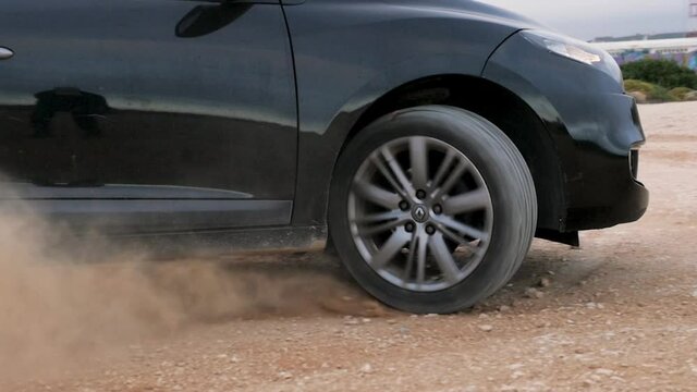 Slow motion of a car wheel drifting on a dirty road