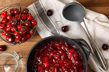 Composition with sweet cherry jam on wooden background, closeup