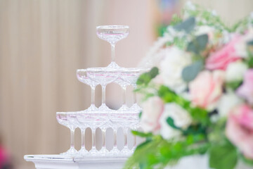 Pyramid of glasses with chilled champagne at wedding ceremony