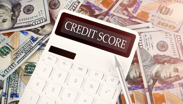 CREDIT SCORE text on display calculator on dollars background