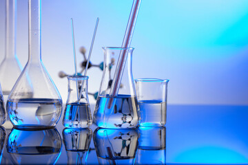 Laboratory investigations. Glass tubes and beakers on blue background.