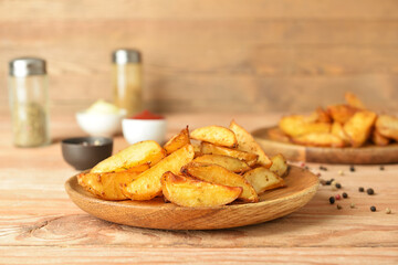 Plate with tasty baked potato on wooden background