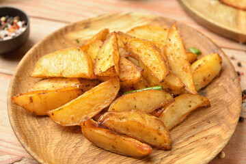 Plate with tasty baked potato on wooden background, closeup