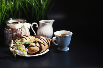 French breakfast on the table. Coffee croissant with chocolate and a decanter with cream. Fresh pastries and decaffeinated coffee.