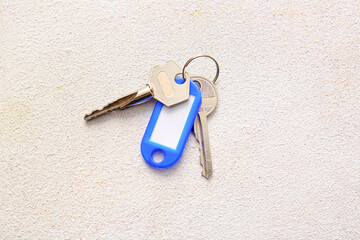 Plastic tag with keys on light background