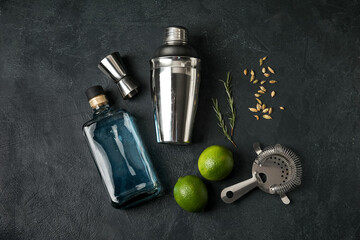 Composition with shaker and ingredients for gin tonic on dark background
