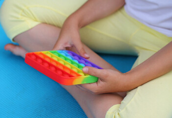 colorful antistress sensory toy fidget push pop it in kid's hands . 