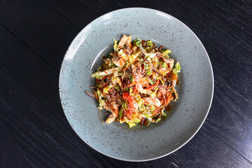Asian wok stir fry served in a plate over dark wooden table. Asian cuisine concept, traditional recipe.