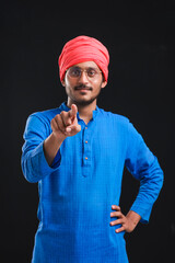 Naklejka premium young indian farmer giving pointing with finger expression.