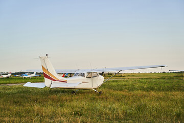 Little plane standing on the territory of airdrome - obrazy, fototapety, plakaty
