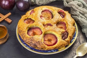 Traditional rustic plum cake on a dark background.