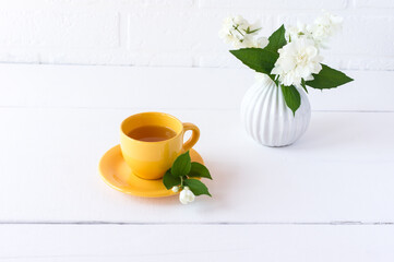 tea with jasmine in a yellow cup with a fragrant smell of sp spies of jasmine flowers. healthy pation.