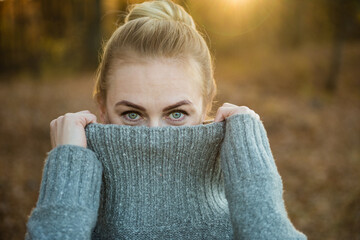 Woman covers part of her face with a sweater. He looks at the camera. Сoncept of abuse, victims,...