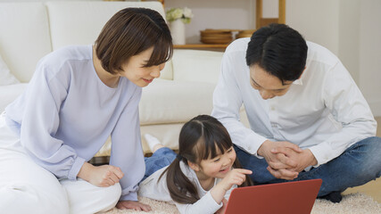 パソコンを見る家族（育児・子育て・家族・ファミリー）