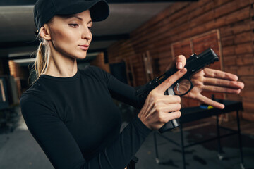 Female concentrated on pulling her gun slide to the rear