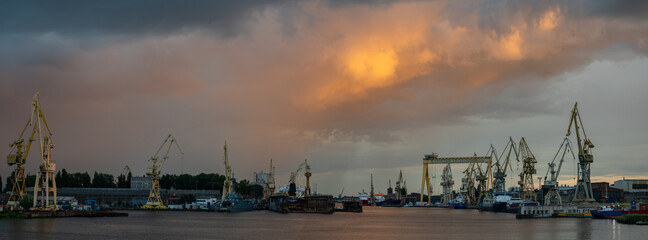 Panoramic view of Szczecin shipyards during a passing evening storm - obrazy, fototapety, plakaty