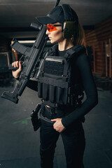 Fototapeta na wymiar Woman with an assault rifle standing at the shooting range