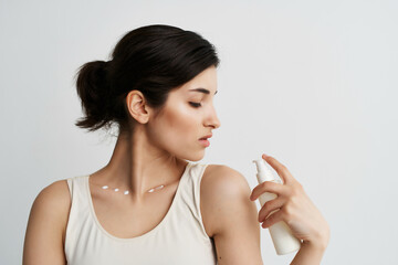 woman in white t-shirt with lotion in hands cosmetics clean skin close-up